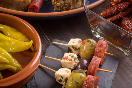 Small appetizers on skewer with cheese, olives and sausage. Tapas or antipasto