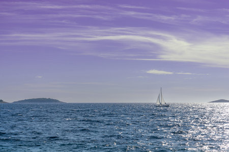 A lone white sail in the afternoon on the immensity of the Adriatic Sea in Croatia. Copy space.の写真素材