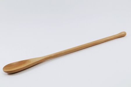 Small spoon made of light wood on a white backgroundの写真素材