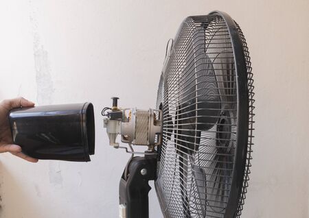 A close up view from bottom to top motor fan repair moving cover from motor and maintenance of home appliances for fixing the fan,  nut and wire copper roll of motor fan on white wall background.の写真素材