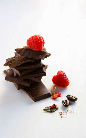 chocolate is stacked together. There are red cherries on top and coffee seed, with white background. There is space for messages.の写真素材