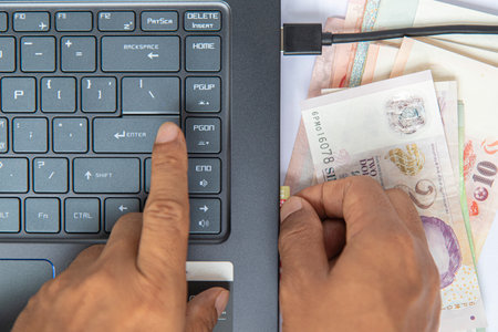 Top view hand put on baknote and black keyboard on notebook have and a memory card plugged into computer on white background have space for text. business online concept, make money online next generation.の写真素材