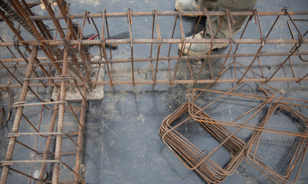 The red sun at dawn was fog over the tip of the rebar in the construction site.