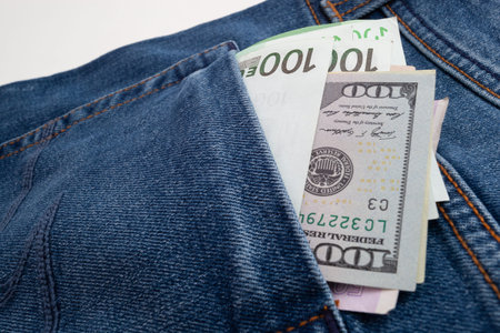 dollars and euro sticking out of jeans pocket
