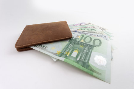 wallet with euro and dollars sticking out of it, isolated