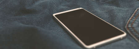 panorama white mobile phone on blue jeansの写真素材