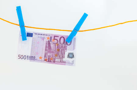 euro banknotes attached with clothespins to a rope on white isolated backgroundの写真素材