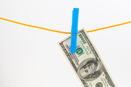 dollars banknotes attached with clothespins to a rope on white isolated backgroundの写真素材