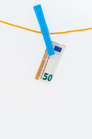 euro banknotes attached with clothespins to a rope on white isolated background