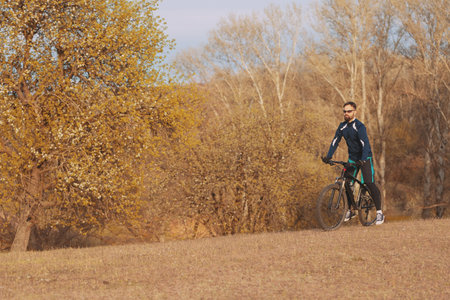 cyclist rides through the autumn forest and park