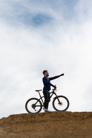 Bearded mountain bicyclist rides mountains