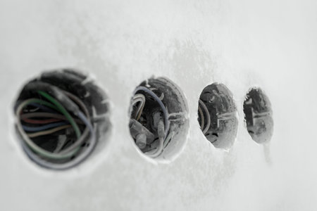 sockets with wires on a putty wall