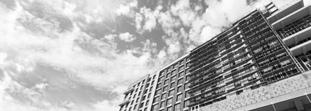 Black and white panorama of a multi-storey residential building under construction and crane on a...