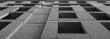 Black and white panorama of a multi-storey residential building under construction and crane on a background of blue skyの写真素材