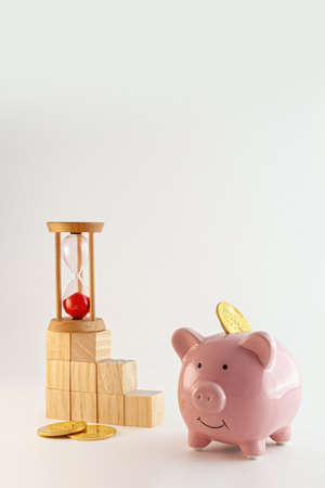 Piggy bank with bitcoin coins, hourglass and wood cubes growing graphic on isolated white backgroundの写真素材