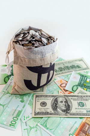 pouch with coins and bitcoins on us dollar and euro banknotesの写真素材