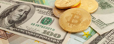 bitcoins on a texture background of euro and dollars panoramaの写真素材