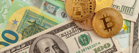 bitcoins on a texture background of euro and dollars panoramaの写真素材