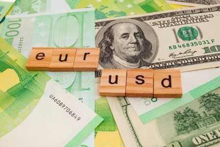USD EUR inscription on wooden cubes on the texture of us dollars and euro banknotes