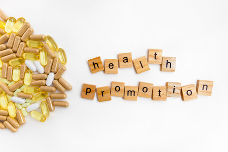 inscription HEALTH PROMOTION in wooden cubes on a white background of different pillsの写真素材