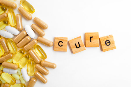 inscription CURE in wooden cubes on a white background of different pillsの写真素材