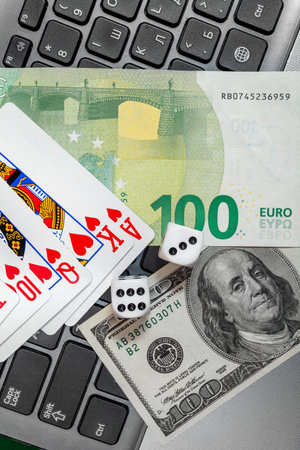 Chisinau, Moldova - 20.12.2020 dice, playing cards on laptop keyboard dollars and euro bills