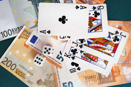 Chisinau, Moldova - 20.12.2020 dice, playing cards on a green cloth in a casino dollars and euro billsの写真素材