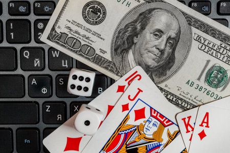 Chisinau, Moldova - 20.12.2020 dice, playing cards on laptop keyboard dollars and euro billsのeditorial素材