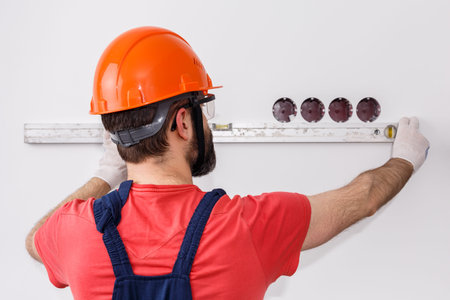 electrician in helmet installs sockets