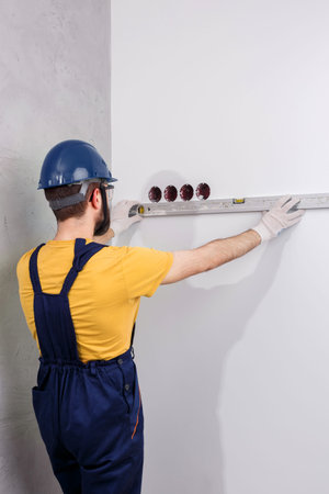 electrician in helmet installs sockets