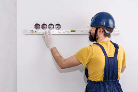 electrician in helmet installs socketsの写真素材