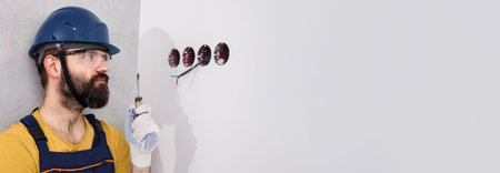 electrician in helmet installs sockets