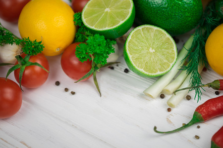 Mix of fresh bright fruits and vegetables on the white wooden background. Healthy eating, vegetarian food concept. Mock up, place for your text.の写真素材