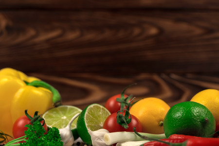 Fresh fruits and vegetables mix on the dark wooden background. Mock up, place for your text.の写真素材