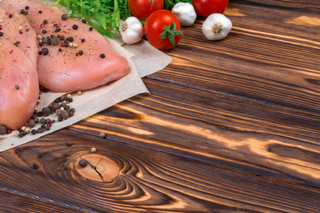Close up of fresh raw chicken fillet with grens and vegetables. Concept of healthy eating. Mock up, copyspace for your text.の写真素材