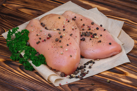 Close up of raw chicken fillet with vegetables and greens on the wooden background.の写真素材