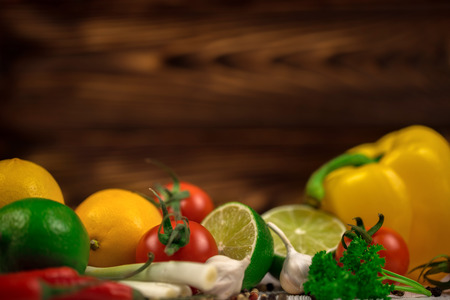 Fresh fruits and vegetables mix on the dark wooden background. Mock up, place for your text.の写真素材
