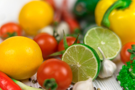 Mix of fresh bright fruits and vegetables on the white wooden background.の写真素材