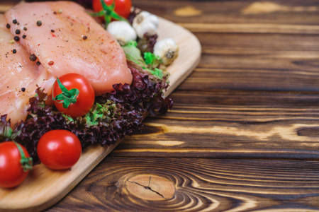 Close up of fresh raw chicken fillet with grens and vegetables. Concept of healthy eating. Mock up, copyspace for your text.の写真素材