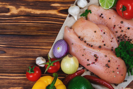 Close up of fresh raw chicken fillet with grens and vegetables. Concept of healthy eating. Mock up, copyspace for your text.の写真素材