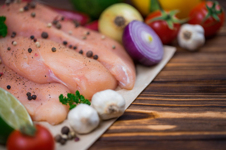 Close up of fresh raw chicken fillet with grens and vegetables. Concept of healthy eating. Mock up, copyspace for your text.の写真素材