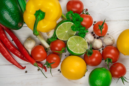 Mix of fresh bright fruits and vegetables on the white wooden background.の写真素材
