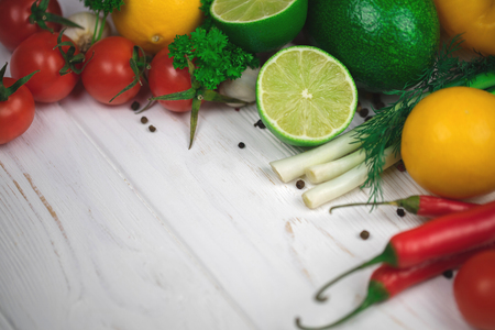 Mix of fresh bright fruits and vegetables on the white wooden background. Healthy eating, vegetarian food concept. Mock up, place for your text.の写真素材