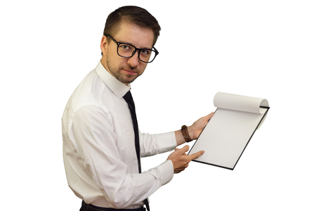 Young business consultant pointing at notepad with blank sheet frowning and looking stricktly. Isolated on white background. Mock up, copy space for your text.の写真素材