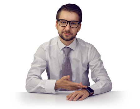 Young boss pointing at his watch with forced smile concealing  irritation about his employee beeing late. Isolated on white background.の写真素材