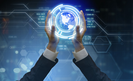 Close up of male hands holding virtual globe icon presenting futuristic technologies.の写真素材