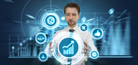Young businessman making presentation in his futuristic office touching virtual panel with media and financial graphs. Modern business and tecnology concept.の写真素材
