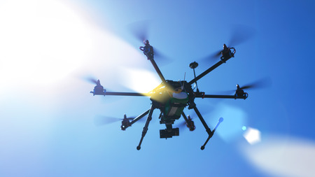 Drone quad copter flying with digital camera. Clear blue sky on the background. Active timespending at sunny day. の写真素材
