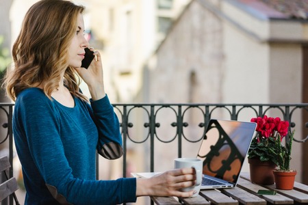 Girl working on the balconyの写真素材
