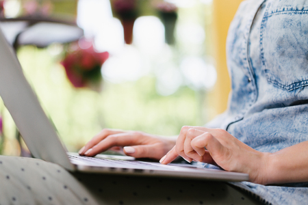 Cropped shot of casual dressed freelancer sitting on her terrace and working using her laptop. Distand work and education in comfortable conditions concept. Horizontal. Copy space for your text.の写真素材
